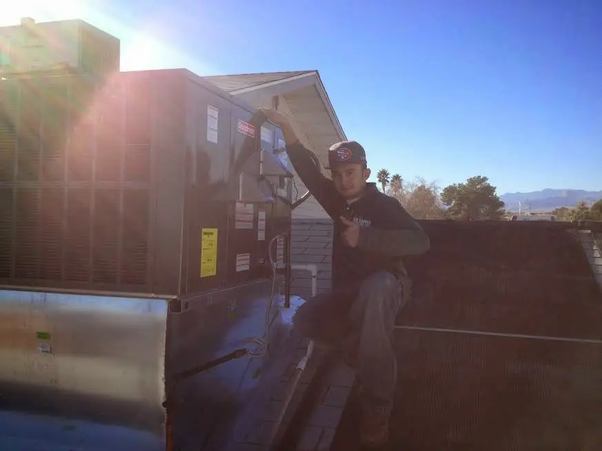HVAC technician performing AC Tune-Up on a rooftop unit in Mount Prospect